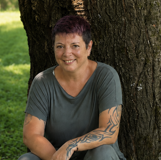 Silke Spies sitzend an einem Baum